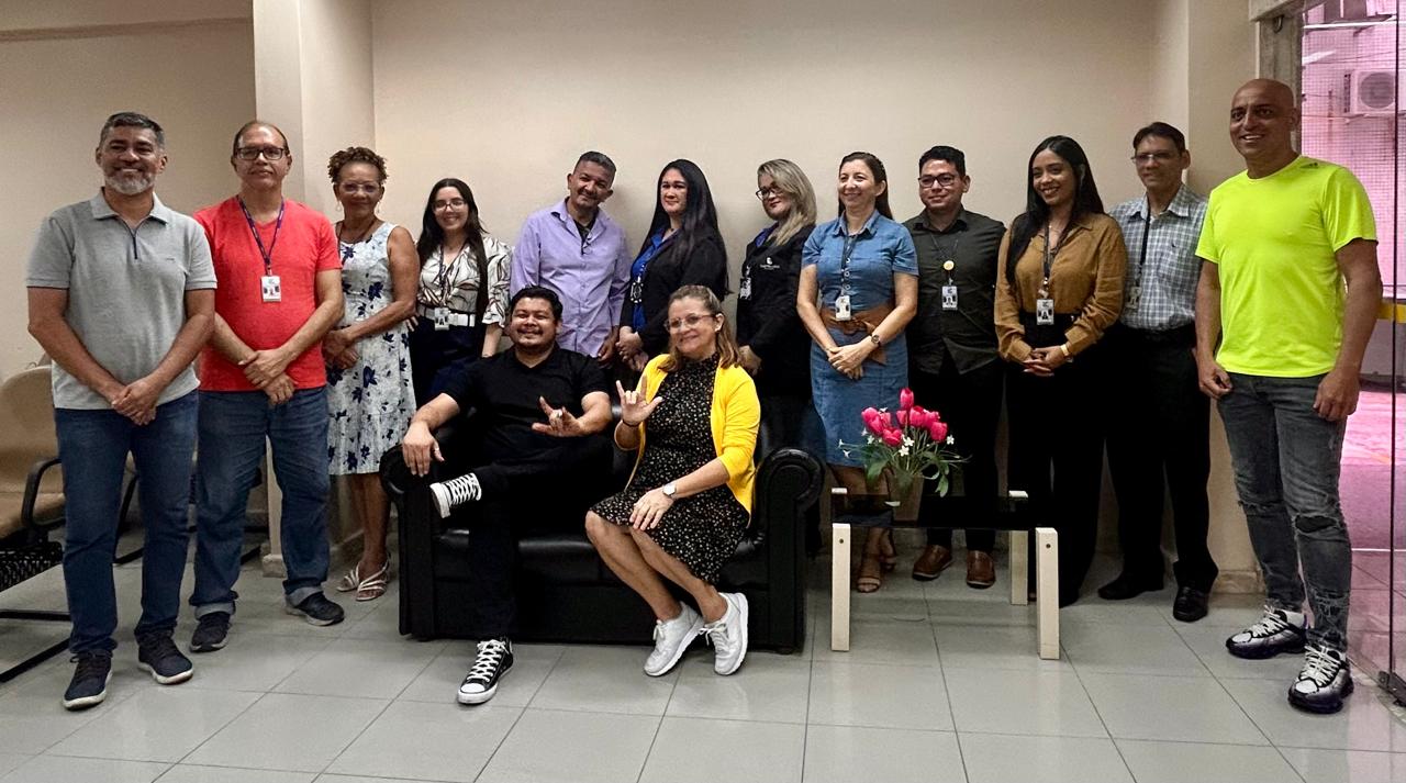 #ParaTodosVerem: Fotografia colorida em ambiente fechado, na foto está presente os alunos e professores do curso de libras, todos estão sorrindo.