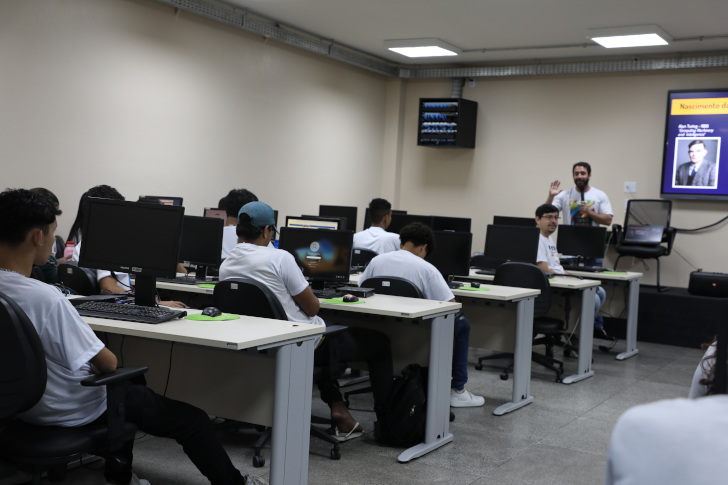 na foto está presente o palestrante e os participantes do curso sentados prestando atenção