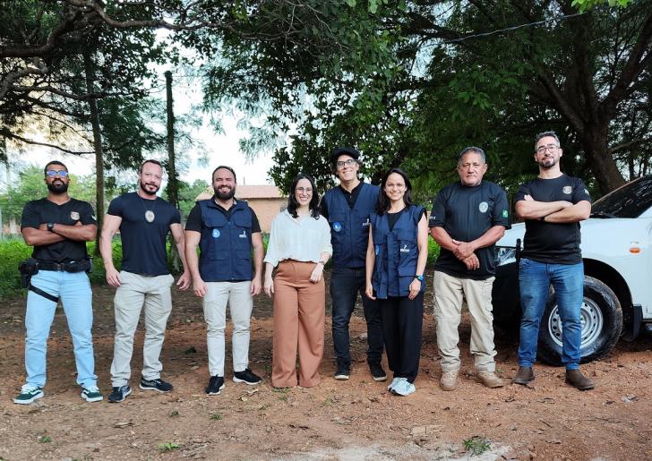 Foto colorida. Em uma estrada de terra, com árvores ao fundo, posam para a foto, lado a lado, magistrado e servidores do TRT-8, além de policiais federais e advogada convidada da itinerância em Conceição do Araguaia.