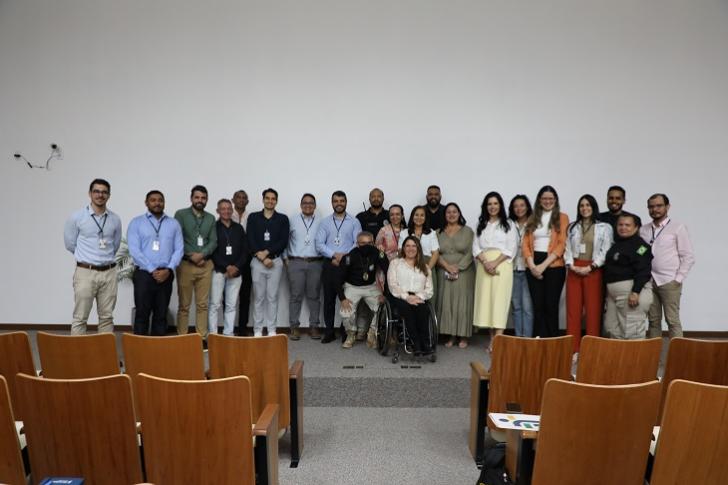  #ParaTodosVerem: Fotografia colorida em ambiente fechado, na foto está reunido as palestrantes e os ouvintes.