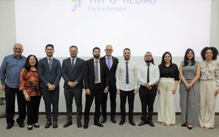 foto colorida dos novos servidores, junto ao presidente e a corregedora do TRT8, no palco do auditório na ejud.