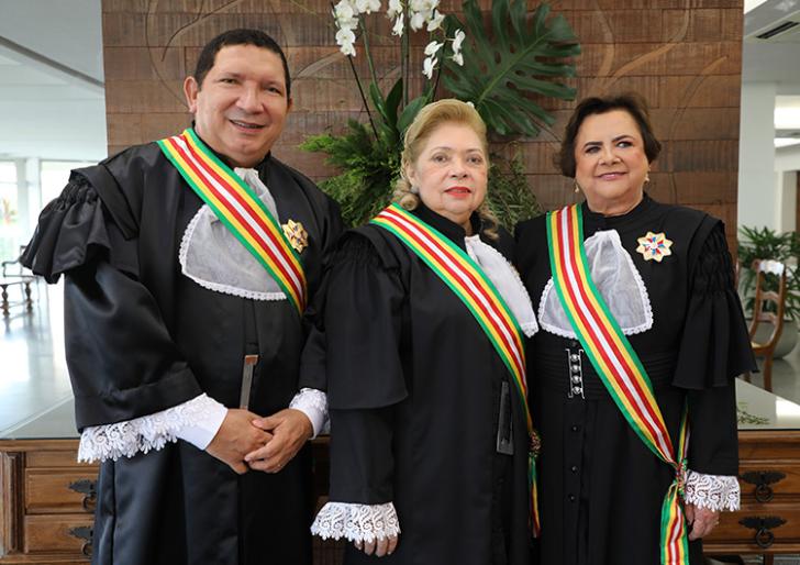 Fotografia que reúne duas mulheres e um homem lado a lado, sorrindo. 