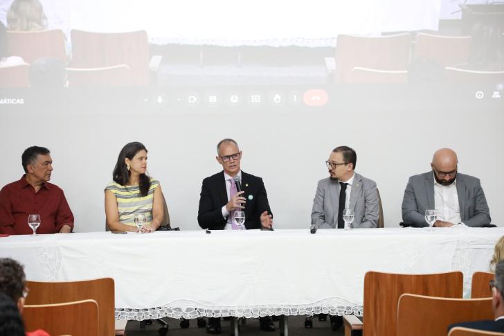 Foto colorida da mesa de abertura do seminário, com a presença de paulo gaia, rejane alves, desembargador marcus augusto losada, desembargador paulo isan junior e arthur homci.