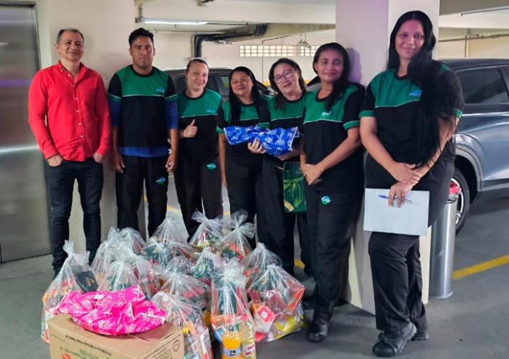 Foto colorida com servidores terceirizados segurando presentes 