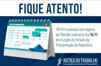 Arte gráfica com fundo azul escuro. No topo, a frase "Fique atento" em letras garrafais na cor azul. Abaixo, uma faixa branca com o texto "TRT-8 funcionará em regime de Plantão Judiciário dia 15/11 em função do feriado da Proclamação da República" na cor azul. Ao lado, a fotografia do calendário no mês de Novembro. No canto inferior esquerdo, a logo da Justiça do Trabalho em branco.