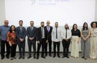 foto colorida dos novos servidores, junto ao presidente e a corregedora do TRT8, no palco do auditório na ejud.