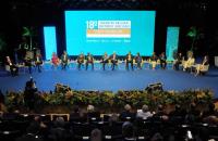 Foto colorida tirada durante a premiação. Os indicados estão no palco sentados durante uma roda de conversa.