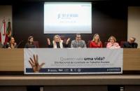 Descrição de imagem: Fotografia em ambiente fechado. Centralizadas, estão sete pessoas sentadas no palco do auditório do TRT-8.  